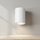 A modern cylindrical LED ceiling light fixture with a matte white outer shade and a glowing warm light visible from the bottom opening, set against a plain white background.
