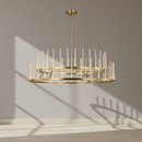 A modern multi-tier chandelier with a brushed gold finish, featuring circular metal rings and numerous slender vertical glass rods, suspended from a matching circular ceiling canopy against a plain white background.